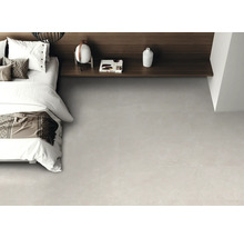 Chambre à coucher moderne avec carrelage de sol gris clair aspect pierre, lit blanc et étagère en bois foncé.