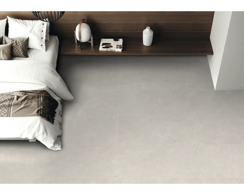 Chambre à coucher moderne avec carrelage de sol gris clair aspect pierre, lit blanc et étagère en bois foncé.