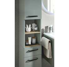 Meuble de salle de bain moderne vert sauge avec étagères ouvertes en bois, tiroirs et poignées noires dans une salle de bain lumineuse.