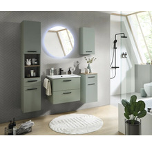 Salle de bain moderne avec meubles vert sauge, meuble sous vasque, armoire haute et miroir LED rond sur un mur carrelé en chevrons.