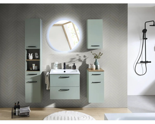 Salle de bains moderne avec meubles vert menthe, miroir LED rond, lavabo, colonne et système de douche noir sur carrelage gris.