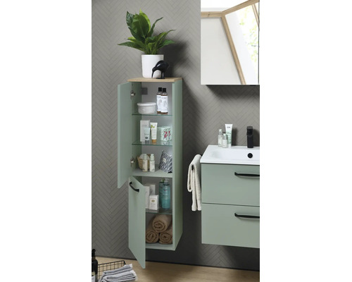 Salle de bain moderne avec armoire haute et meuble sous-vasque vert menthe. Armoire avec étagères en verre. Lavabo avec robinet noir.