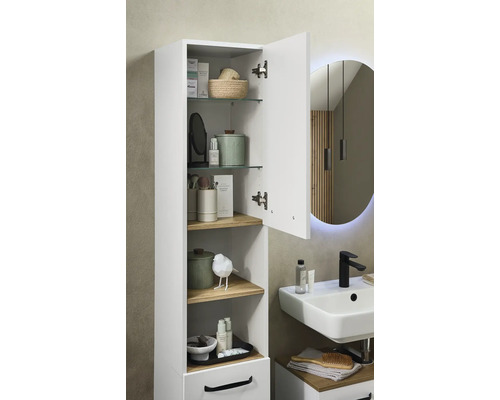 Armoire haute blanche de salle de bain, porte ouverte, tablettes en verre et bois, près d'un lavabo avec robinet noir, style moderne et organisé.