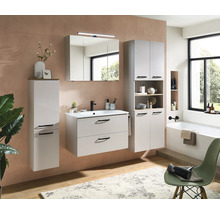 Ensemble de meubles de salle de bains moderne gris clair avec sous-vasque, armoire de toilette éclairée et colonnes dans une pièce lumineuse.