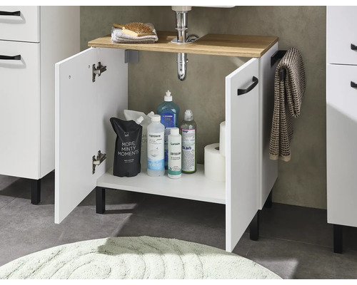 Meuble sous-vasque avec deux portes ouvertes, plateau aspect bois, poignées et pieds noirs, avec produits de nettoyage et accessoires de salle de bain.