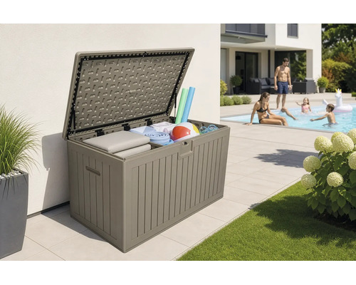 Coffre de jardin ouvert en plastique avec des coussins et des accessoires de piscine sur une terrasse à côté d'une piscine.