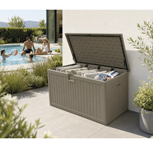 Coffre de jardin ouvert en plastique aspect bois, rempli de coussins et d'accessoires de piscine sur une terrasse à côté d'une piscine.