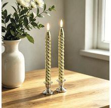 Zwei gedrehte LED-Stabkerzen in Gold auf silbernen Kerzenständern auf einem Holztisch neben einer weißen Vase mit Blumen.