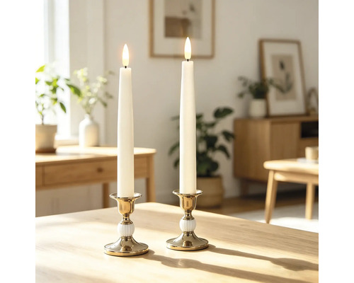 Zwei LED-Stabkerzen in goldfarbenen Haltern auf einem Holztisch in einem hellen Wohnzimmer mit Pflanzen und Holzmöbeln.
