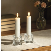 Deux bougies LED blanches dans des bougeoirs en verre transparent en forme de cube sur une table.