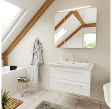 Badezimmer mit weissem Waschtischunterschrank, Keramikwaschbecken und dreitürigem Spiegelschrank mit Beleuchtung in einem hellen Dachgeschossraum.