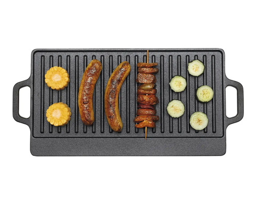Plaque de grillade en fonte avec saucisses, maïs, brochette de viande et rondelles de courgettes.