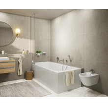 Modernes, helles Badezimmer mit weißer Badewanne, wandhängendem Bidet, Waschtisch mit Holzfront, rundem Spiegel und grauen Wandfliesen.