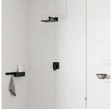 Douche lumineuse avec carrelage blanc, pomme de douche de tête noire, mitigeur encastré noir et étagère de douche noire avec porte-serviette.
