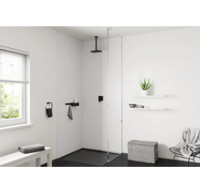 Salle de bains moderne et lumineuse avec douche à l'italienne, pommeau de douche noir au plafond, paroi en verre et accessoires noirs.