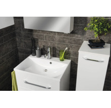 Modernes Badezimmer mit weissem Waschtischunterschrank, Waschbecken und Seitenschrank vor dunklen Wandfliesen in Steinoptik.