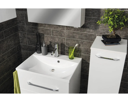 Modernes Badezimmer mit weissem Waschtischunterschrank, Waschbecken und Seitenschrank vor dunklen Wandfliesen in Steinoptik.