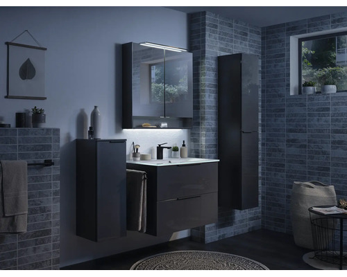 Salle de bain moderne avec meuble sous-vasque gris foncé, lavabo, armoire de toilette avec éclairage LED et colonnes de rangement sur murs carrelés.