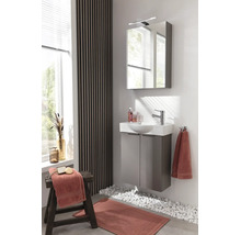 Modernes helles Badezimmer mit grauem Waschbeckenunterschrank, weißem Waschbecken, Spiegelschrank mit Leuchte und Wand mit Holzlamellen.