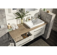 Moderner Badezimmer-Waschtisch mit weissem Aufsatzbecken, Platte in Eichenoptik und weissem Unterschrank mit zwei Schubladen.