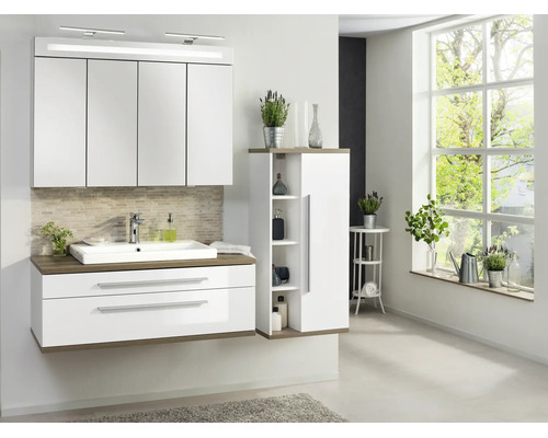 Ensemble de salle de bains moderne blanc avec accents bois, comprenant armoire de toilette éclairée, meuble sous-lavabo et armoire haute.