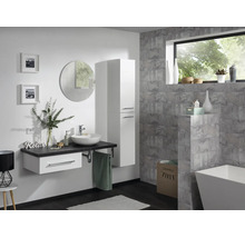 Salle de bain moderne avec meuble sous-vasque blanc, plan de travail sombre, vasque à poser, armoire haute et miroir rond.