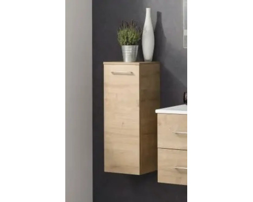 Meuble de salle de bain latéral suspendu en décor chêne avec porte et poignée en métal dans une salle de bain moderne.