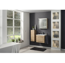 Salle de bain moderne et lumineuse avec meubles en aspect bois, vasque blanche, armoire de toilette, baignoire îlot et grande fenêtre.