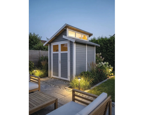 Abri de jardin moderne en bois gris avec bordures blanches, porte double vitrée et impostes dans un jardin éclairé.