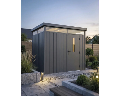 Abri de jardin moderne en métal avec toit plat et fenêtres imposte dans un jardin organisé avec des dalles en pierre et des plantes.