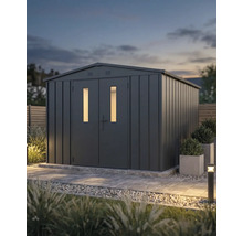Abri de jardin moderne en métal anthracite avec double porte et deux fenêtres verticales dans un jardin paysager au crépuscule.