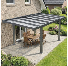 Toiture de terrasse moderne en aluminium anthracite avec toit translucide sur une terrasse pavée avec mobilier de jardin.