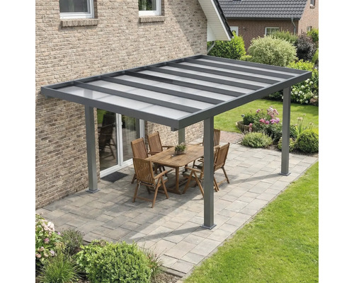 Toiture de terrasse moderne en aluminium anthracite avec toit translucide sur une terrasse pavée avec mobilier de jardin.