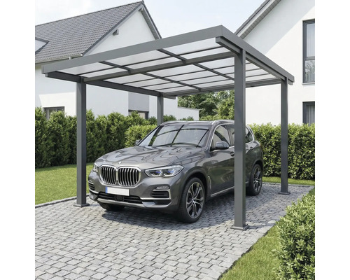 Carport moderne en aluminium avec toit translucide au-dessus d'un véhicule sur une allée pavée devant une maison.