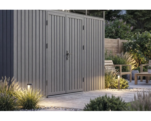 Abri de jardin moderne gris en métal avec double porte sur une terrasse en pierre avec éclairage extérieur.
