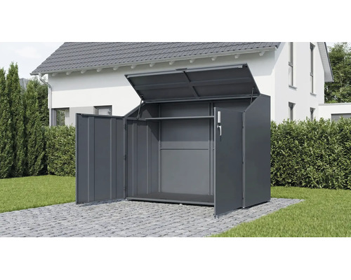 Geöffnete Gerätebox aus Metall für Mülltonnen oder Fahrräder auf einer gepflasterten Fläche im Garten vor einem Wohnhaus.