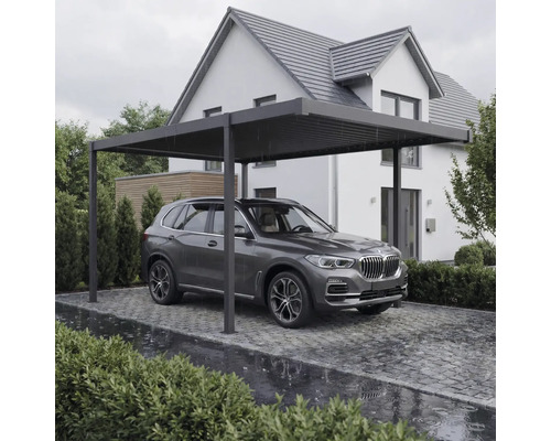 Modernes Carport aus Metall mit Flachdach vor einem Wohnhaus, schützt ein Auto auf einer gepflasterten Einfahrt.