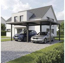 Abri de voiture double moderne en métal avec toit plat devant une maison, allée pavée avec deux voitures.
