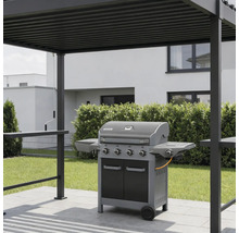 Barbecue à gaz avec quatre brûleurs et tablettes latérales sur une terrasse pavée sous une pergola moderne en métal dans un jardin.