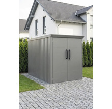 Abri de jardin moderne en métal avec double porte et toit plat, installé sur un pavage extérieur.