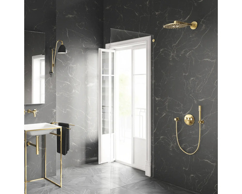 Modernes Badezimmer mit dunklen Marmorfliesen, goldenen Duscharmaturen, Glaswand und weißem Waschbecken mit Goldgestell.