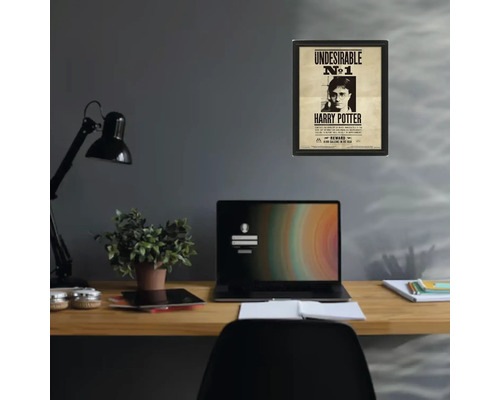 Poster Harry Potter Undesirable numéro 1 encadré sur un mur gris au-dessus d un bureau en bois organisé avec ordinateur portable et lampe.