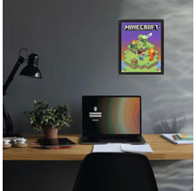 Poster Minecraft dans un cadre noir sur un mur sombre au-dessus d'un bureau avec un ordinateur portable et une plante.
