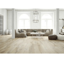 Heller, geräumiger Wohnraum mit hellem Holzfußboden, großem Modulsofa, weißem Couchtisch und großen Bogenfenstern.
