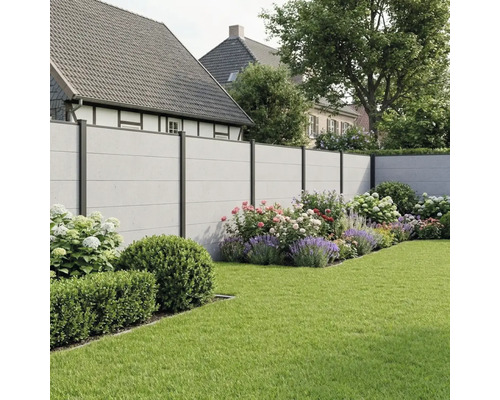Clôture de jardin moderne avec panneaux aspect béton et poteaux métalliques foncés dans un jardin avec parterres de fleurs et pelouse.