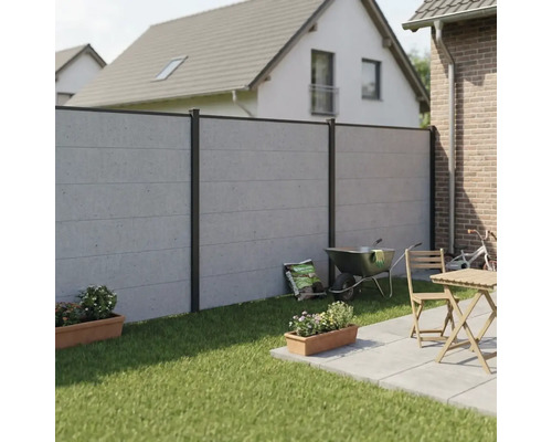 Clôture de jardin moderne en aspect béton avec poteaux en aluminium foncé, installée sur une pelouse à côté d'une terrasse.