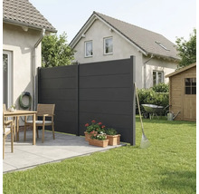 Brise-vue moderne de couleur anthracite composé de deux panneaux sur une terrasse carrelée à côté d'une pelouse et de meubles de jardin.