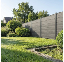 Clôture brise-vue moderne en bois composite avec poteaux noirs dans un jardin bien entretenu avec pelouse.