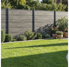 Clôture de jardin moderne grise en bois composite avec poteaux métalliques installée dans un jardin avec pelouse et arbustes.