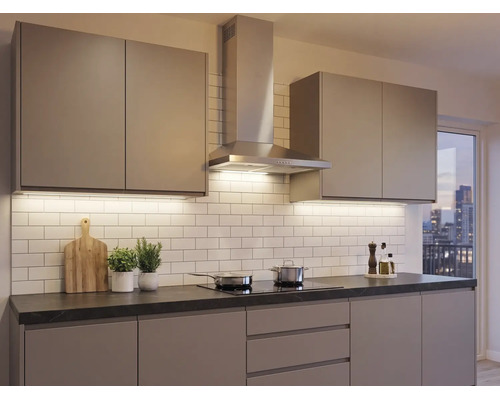 Cuisine intégrée moderne avec façades sans poignées, hotte aspirante en inox, plan de travail sombre et crédence blanche.